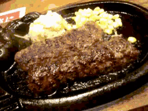 a close up of a steak on a sizzling plate
