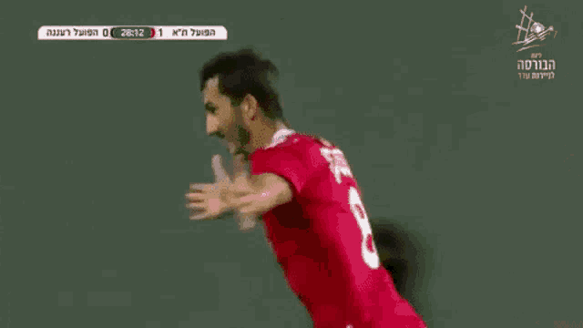 a soccer player in a red jersey is laying on the field during a game