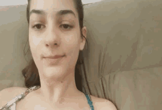 a close up of a woman laying on a couch making a funny face .