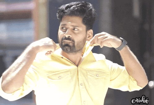 a man in a yellow shirt is adjusting his shirt collar with a watch on his wrist