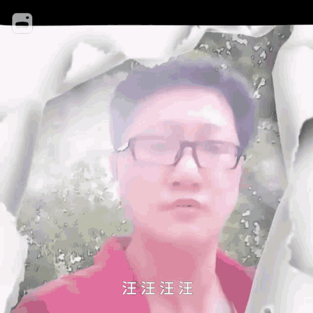 a man wearing glasses and a red shirt is behind a piece of paper