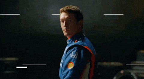 a man in a honda jacket stands in a dark room