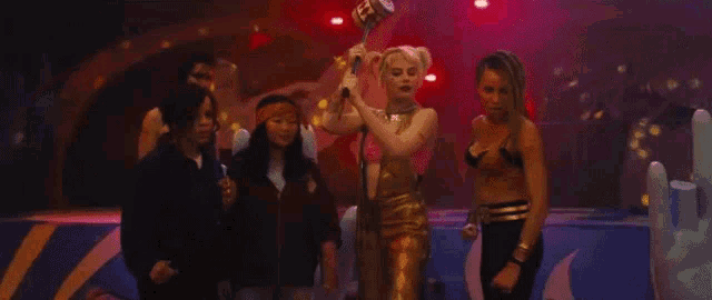 a group of women standing next to each other on a stage in a dark room .