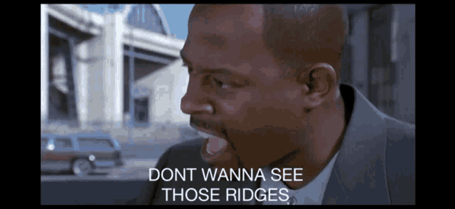 a man in a suit is screaming with the words " dont wanna see those ridges " below him