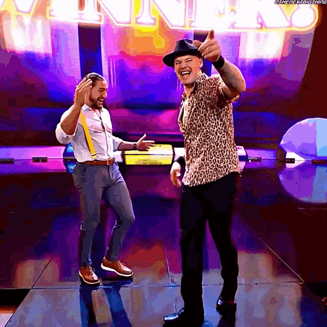 two men are dancing in front of a sign that says ' winner '