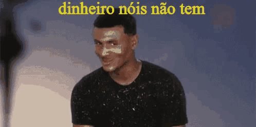 a man with paint on his face is standing in front of a sign that says dinheiro nois nao tem .