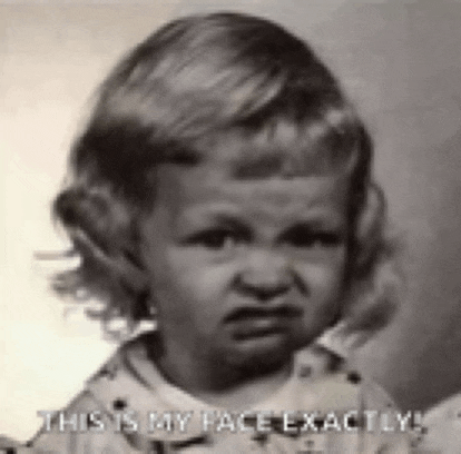 a black and white photo of a little girl with a very angry face .