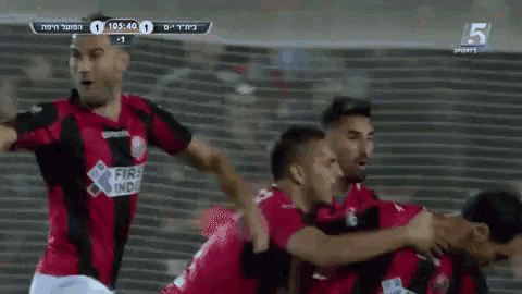a group of soccer players wearing red and black jerseys with the number 5 on the bottom right