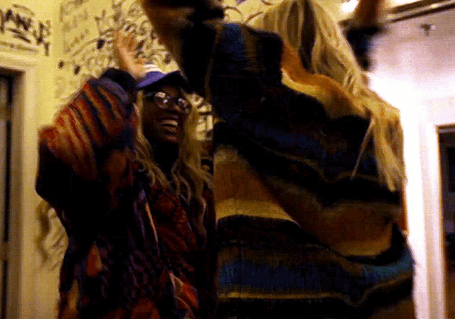 a woman in a colorful sweater is standing next to another woman