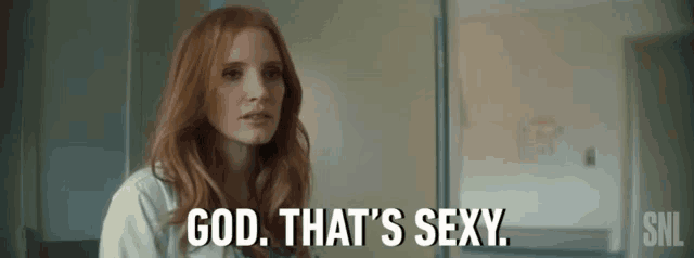 a woman with red hair is sitting in front of a refrigerator and says `` god , that 's sexy '' .