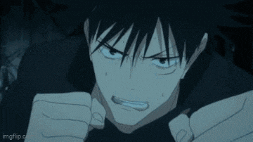 a close up of a person 's face in a dark room with a fist in the air .