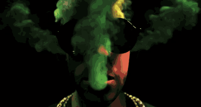 a man is smoking a cigarette with green and yellow smoke coming out of his face .