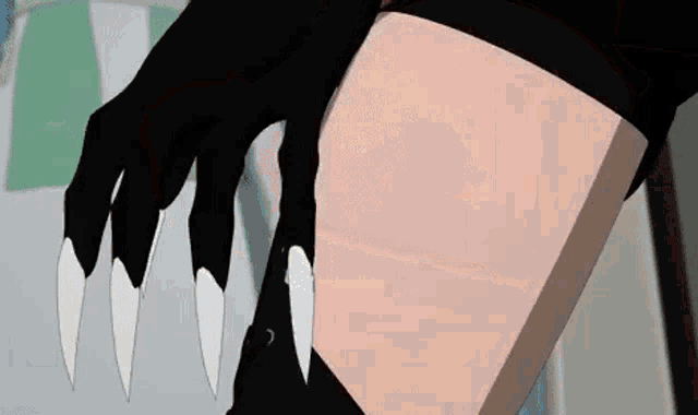 a close up of a person 's leg with a black glove and white claws .