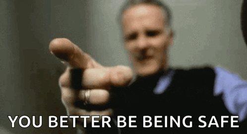 a man is pointing at the camera with his finger and the words `` you better be being safe '' written below him .