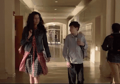 a woman and a boy walking down a hallway