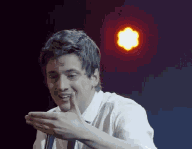 a man giving a thumbs up in front of a red light
