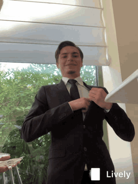 a man in a suit and tie adjusts his tie with a lively icon in the corner