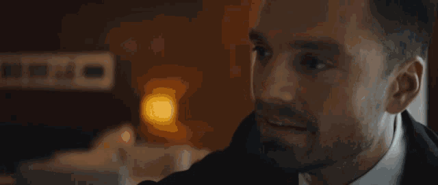 a man in a suit and tie is holding a lit candle