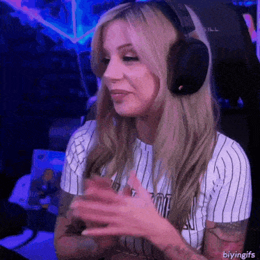 a woman wearing headphones and a striped shirt with the letters tmt on it