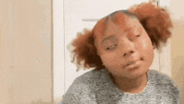 a woman with red hair is making a funny face with her eyes closed .