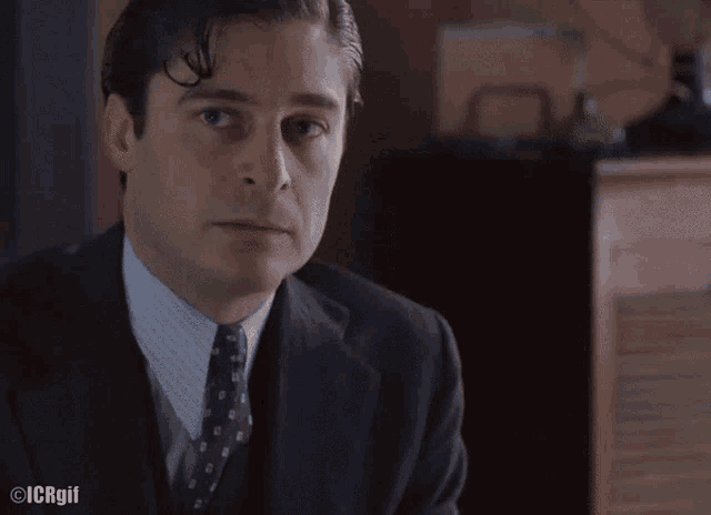 a man in a suit and tie with icrgil written on the bottom