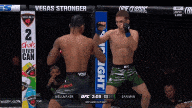 two men in a boxing ring with a sign that says vegas stronger on it