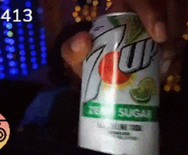 a person is holding a can of 7 up that is zero sugar