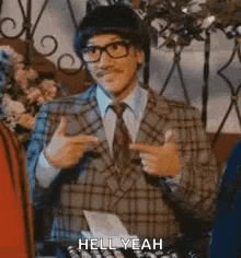a man in a suit and tie is pointing at something with his fingers .
