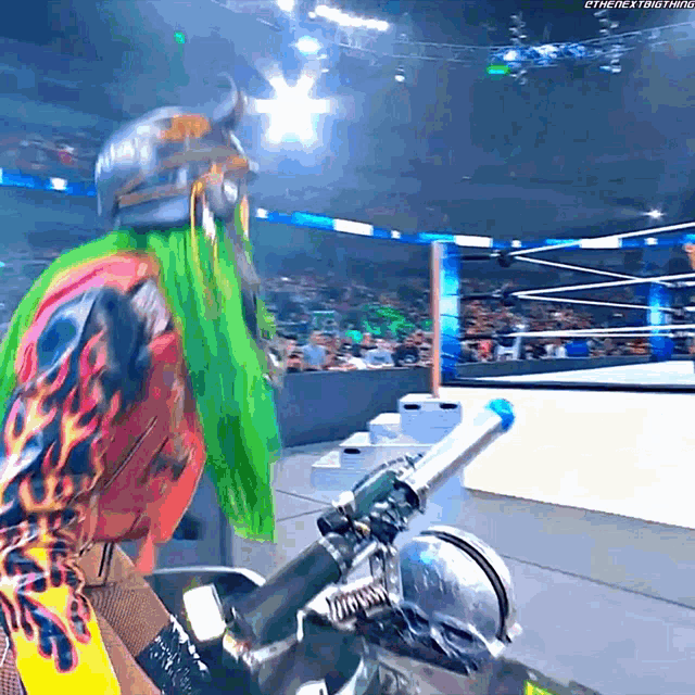 a man with green hair and a helmet is riding a motorcycle in a wrestling ring