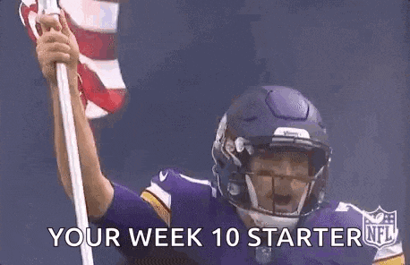 a football player in a helmet is holding an american flag .