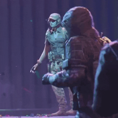 two soldiers are standing next to each other on a stage in a video game .