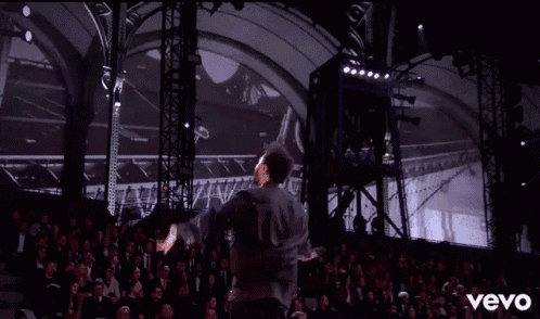 a man is dancing on a stage in front of a crowd and the word vevo is on the bottom of the screen