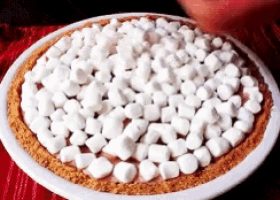 a pie covered in marshmallows on a plate