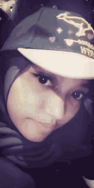 a woman wearing a hijab and a hat that says fox on it