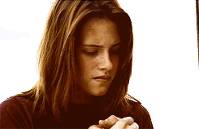 a woman with long brown hair is wearing a red shirt