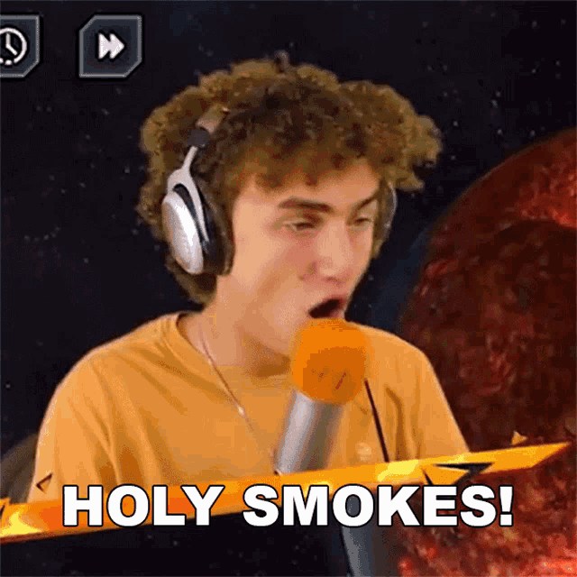 a young man wearing headphones says holy smokes in front of a microphone