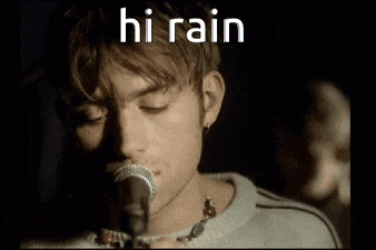 a close up of a man singing into a microphone with the words hi rain above him