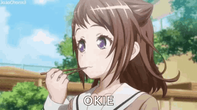 a girl in a school uniform is eating with chopsticks and the word okie is on the bottom of her face .