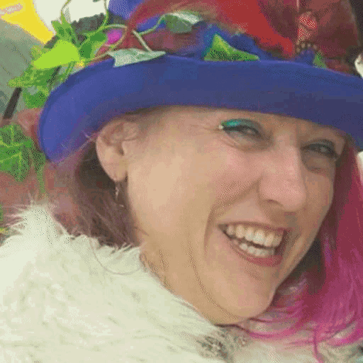 a woman with pink hair is wearing a blue hat