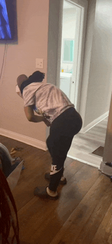 a person wearing nike pants is squatting down in a living room