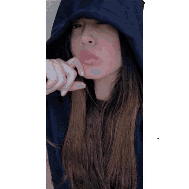 a woman wearing a hooded sweatshirt has a pink lipstick on her lips