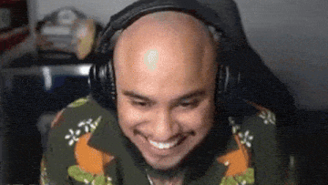 a bald man wearing headphones and a shirt is smiling .