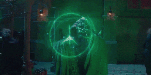 a group of people are standing in a dark room with a green light coming from the ceiling .