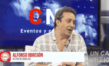 a man is sitting in front of a screen that says alfonso obregon