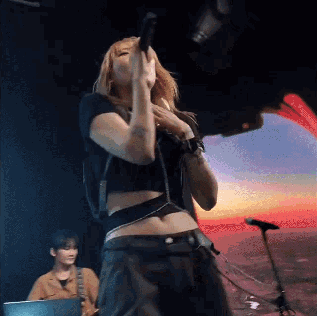 a woman singing into a microphone on stage