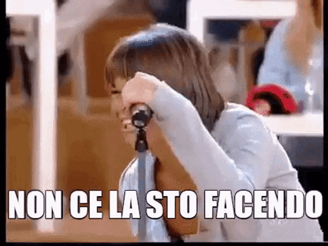 a woman is singing into a microphone with the words non ce la sto facendo written on the screen .