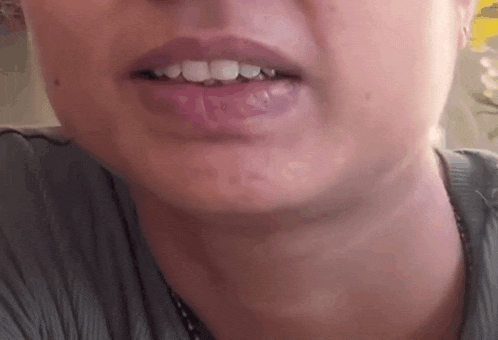 a close up of a woman 's face with her mouth open and her teeth showing .