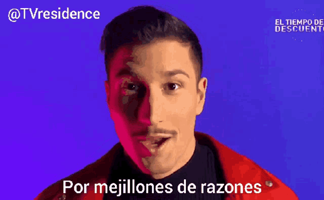 a man in a red jacket is smiling with the words por mejillone de razones below him