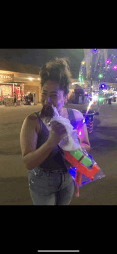 a woman eating an ice cream cone in front of a store that says toos