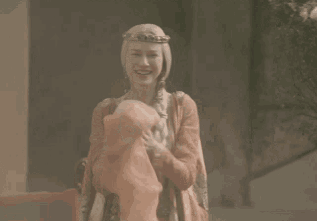 a woman wearing a crown is smiling and holding a cloth